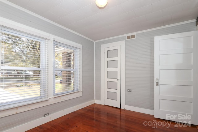 unfurnished bedroom with dark hardwood / wood-style floors and ornamental molding