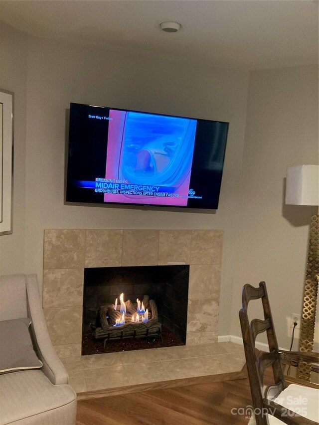 room details featuring a tile fireplace and wood-type flooring