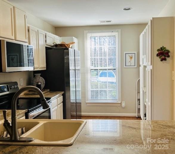 kitchen featuring light wood-type flooring, refrigerator, electric stove, and sink