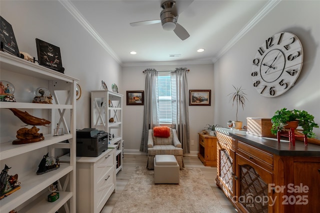 sitting room with ceiling fan, crown molding, and light wood-type flooring