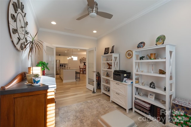 office area featuring light wood-type flooring, ceiling fan, and crown molding