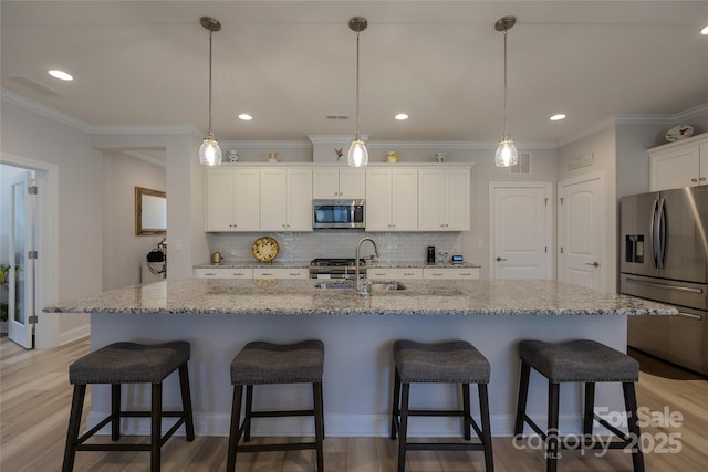 kitchen featuring sink, decorative light fixtures, a center island with sink, white cabinets, and appliances with stainless steel finishes