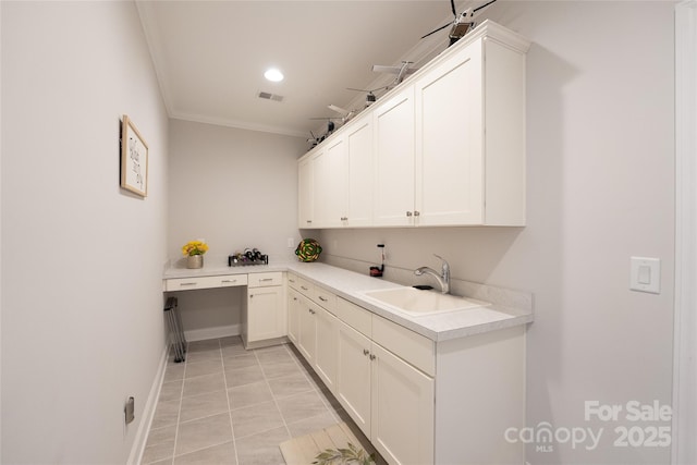 laundry room featuring crown molding, light tile patterned floors, and sink