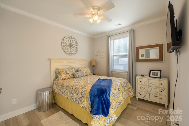 bedroom with ceiling fan, crown molding, and light wood-type flooring