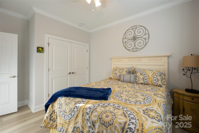 bedroom featuring light wood-type flooring, a closet, ceiling fan, and crown molding