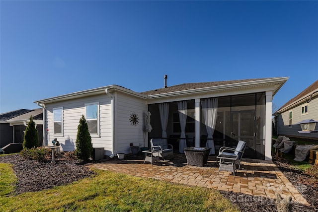 rear view of house featuring a sunroom and a patio