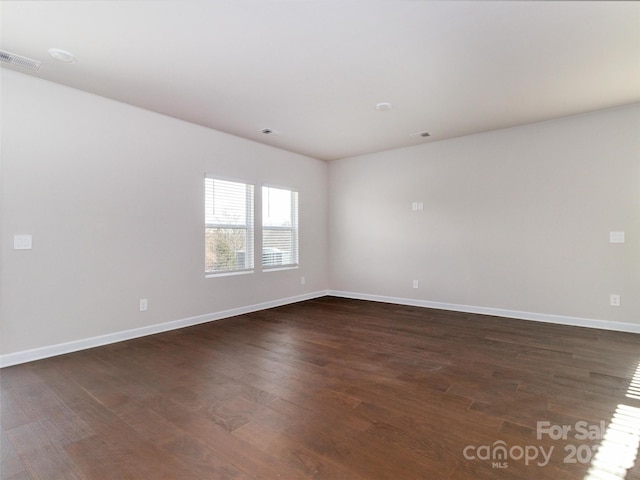 spare room with dark wood-type flooring