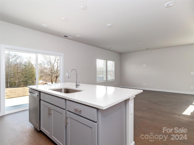 kitchen with dark wood-type flooring, sink, a center island with sink, dishwasher, and gray cabinets