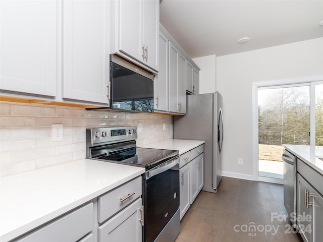 kitchen featuring gray cabinets, decorative backsplash, dark hardwood / wood-style flooring, and stainless steel appliances