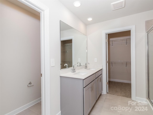 bathroom with tile patterned floors, vanity, and an enclosed shower