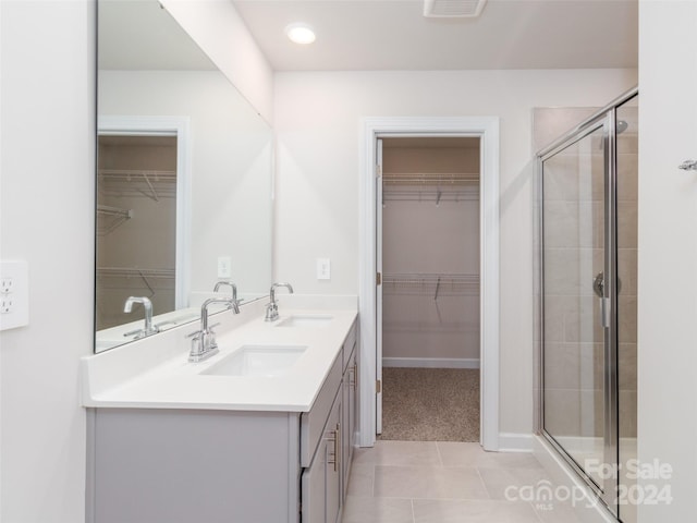 bathroom featuring vanity, tile patterned floors, and a shower with shower door