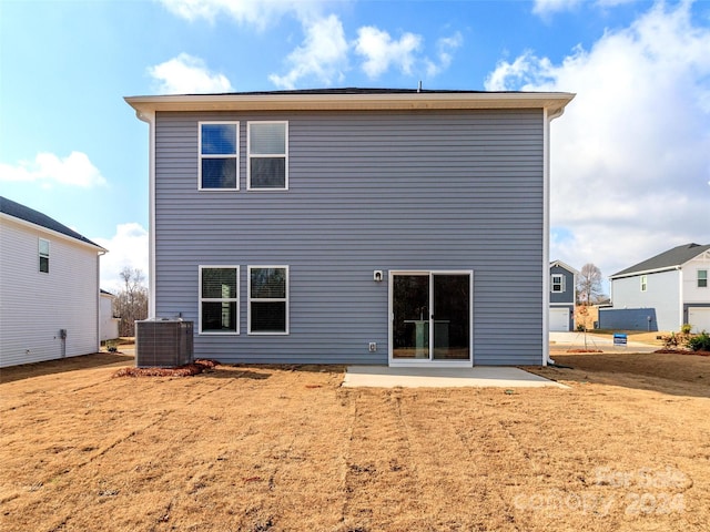 rear view of house with central air condition unit, a patio area, and a lawn