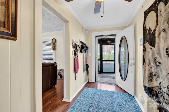 foyer with a textured ceiling, ceiling fan, dark hardwood / wood-style flooring, and crown molding