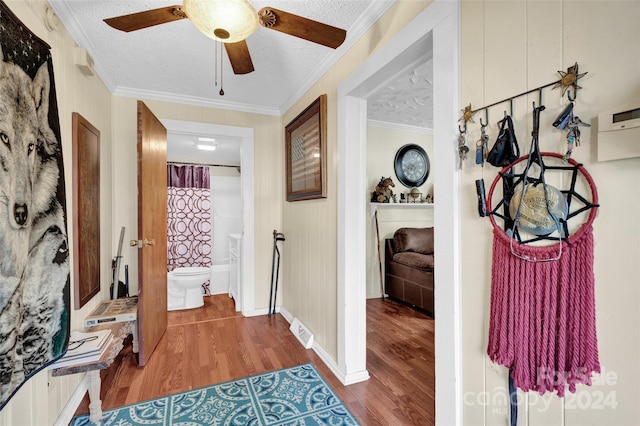 hallway featuring hardwood / wood-style floors, a textured ceiling, and crown molding