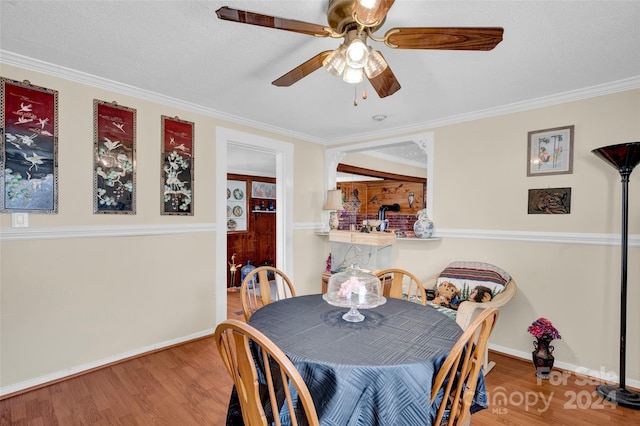 dining area with hardwood / wood-style flooring, a textured ceiling, and ornamental molding