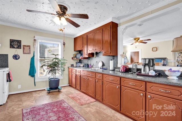 kitchen featuring white range with electric cooktop, crown molding, sink, and washer and dryer