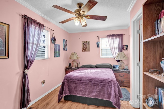 bedroom with ceiling fan, hardwood / wood-style floors, crown molding, and a textured ceiling