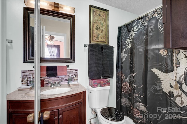 bathroom featuring decorative backsplash, vanity, a textured ceiling, and toilet