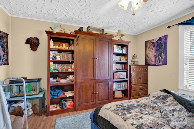 bedroom featuring multiple windows, a textured ceiling, and light wood-type flooring