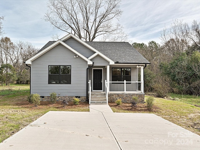 bungalow-style home with covered porch and a front yard