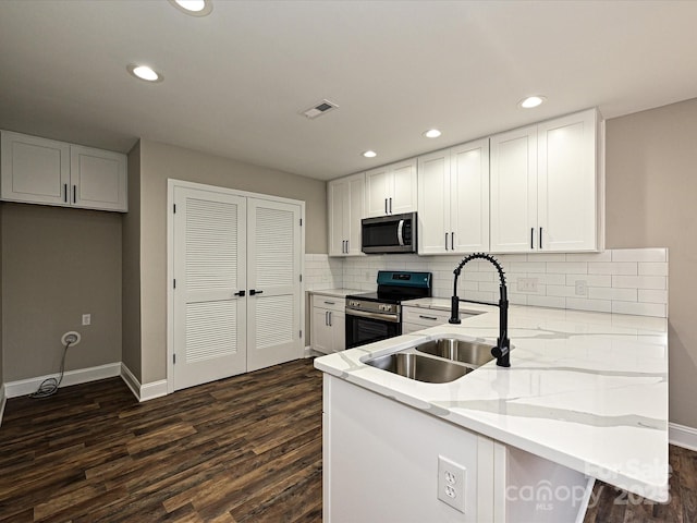 kitchen with stainless steel appliances, visible vents, white cabinets, a sink, and a peninsula