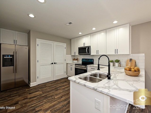 kitchen with a peninsula, visible vents, appliances with stainless steel finishes, and white cabinets