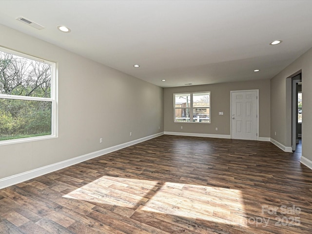 spare room featuring baseboards, dark wood-type flooring, visible vents, and recessed lighting