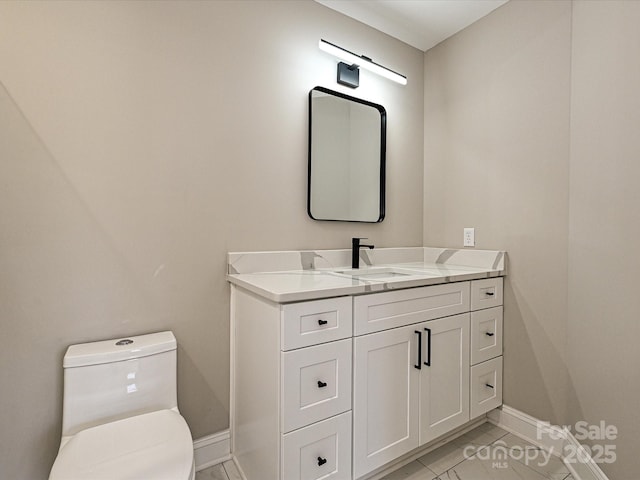 bathroom featuring toilet, baseboards, and vanity