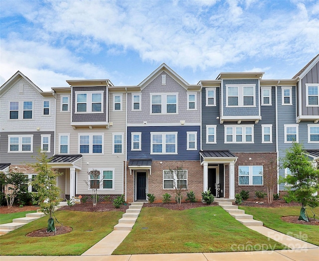 townhome / multi-family property featuring a front lawn