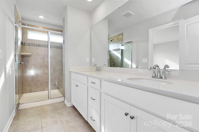 bathroom with tile patterned flooring, vanity, and a shower with door