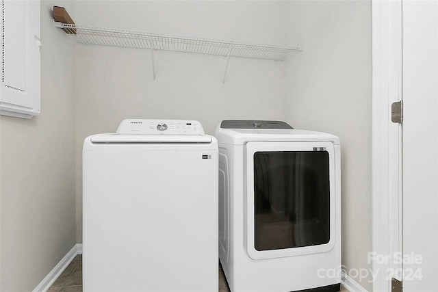 clothes washing area featuring tile patterned floors and washer and clothes dryer