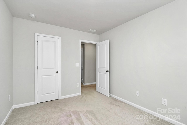 unfurnished bedroom with light colored carpet