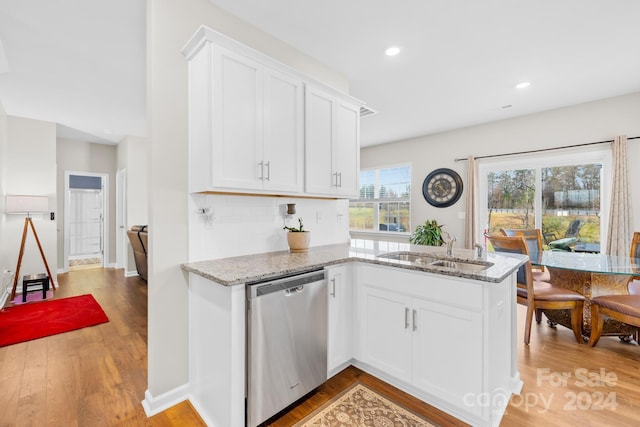 kitchen featuring stainless steel dishwasher, white cabinetry, sink, and light hardwood / wood-style flooring