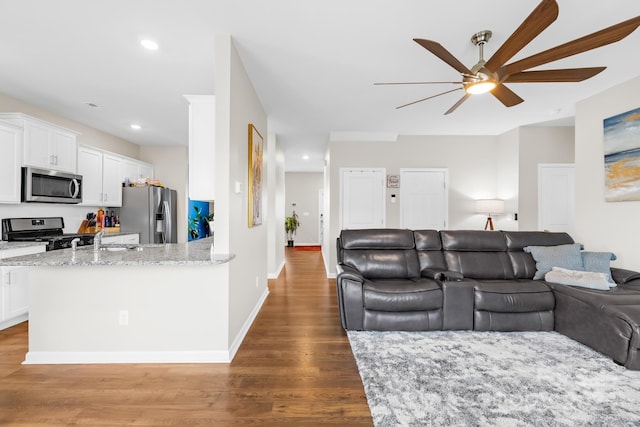 living room with ceiling fan, wood-type flooring, and sink