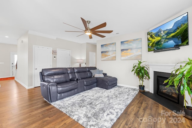 living room with ceiling fan and dark hardwood / wood-style flooring