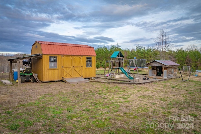 view of jungle gym with a trampoline and a storage unit