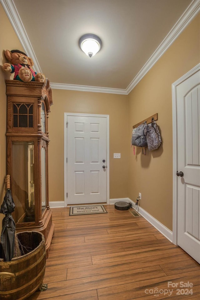 entryway featuring wood-type flooring and ornamental molding