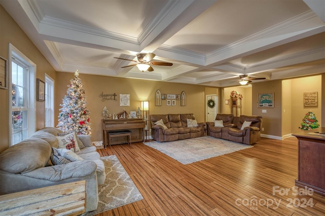 living room with ceiling fan, light wood-type flooring, crown molding, and coffered ceiling