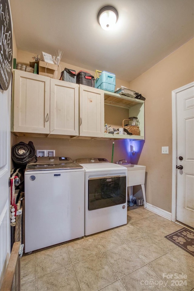 laundry area featuring cabinets, independent washer and dryer, sink, and light tile patterned floors