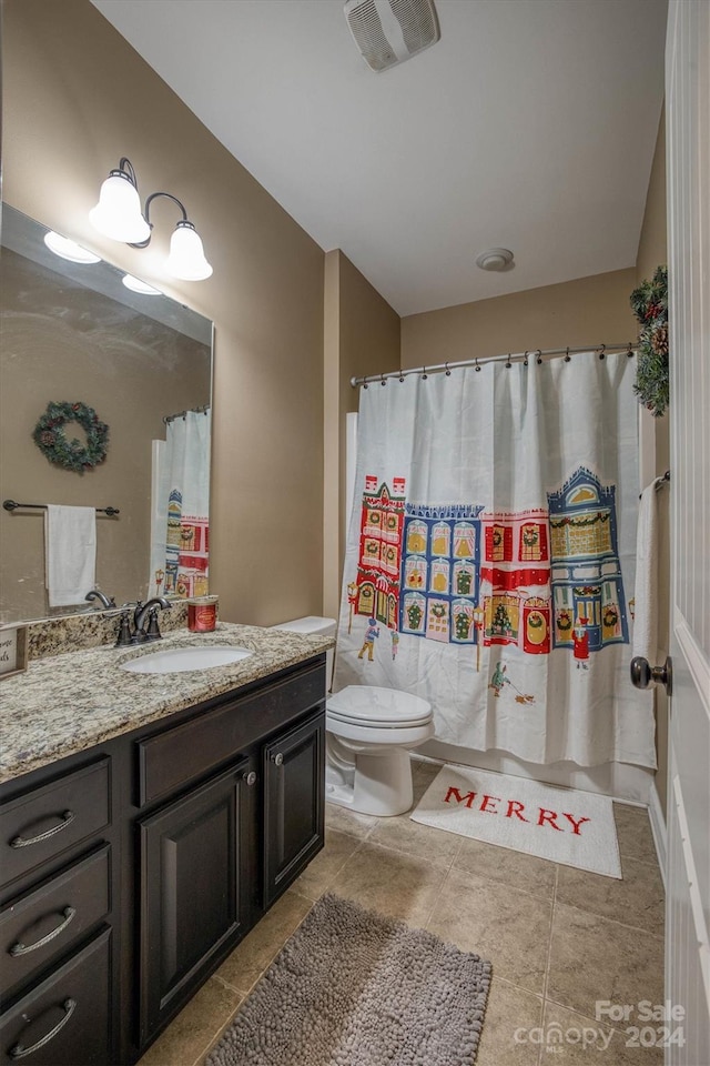 bathroom featuring tile patterned flooring, vanity, and toilet