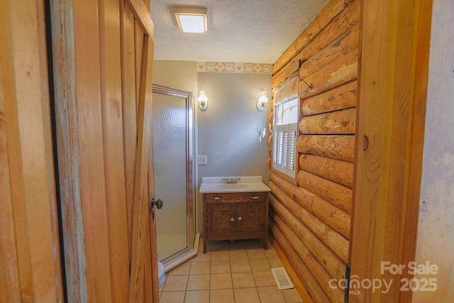 bathroom featuring log walls, tile patterned flooring, vanity, an enclosed shower, and a textured ceiling