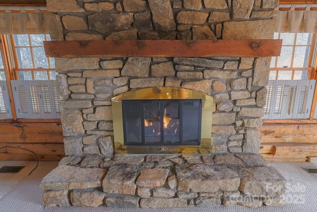 room details with a stone fireplace and carpet floors