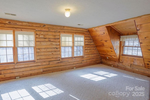 additional living space with carpet and rustic walls