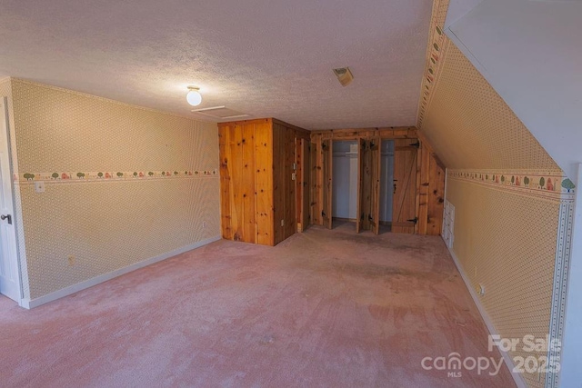 bonus room featuring vaulted ceiling, carpet, and a textured ceiling