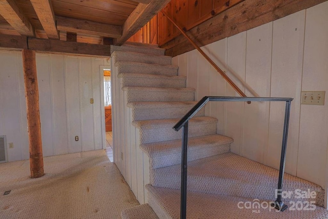 stairway featuring carpet floors and beam ceiling