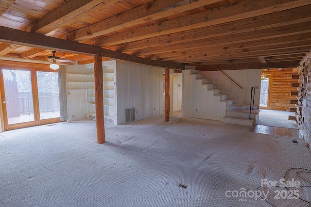 interior space featuring beamed ceiling, ceiling fan, light carpet, and wood ceiling