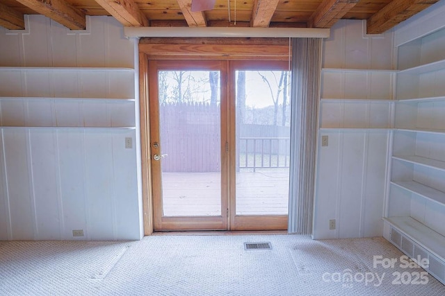 doorway to outside featuring wood ceiling, carpet floors, and beamed ceiling