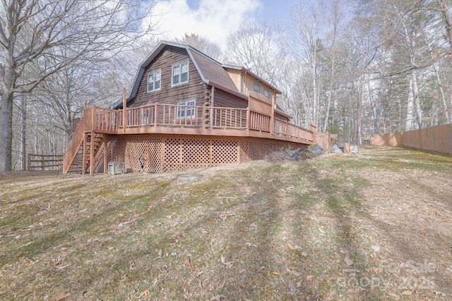 back of house with a lawn and a deck