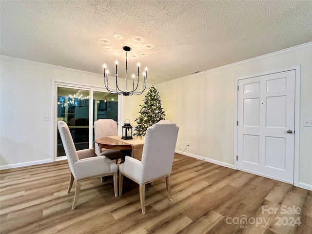 dining area with hardwood / wood-style floors, a textured ceiling, and an inviting chandelier