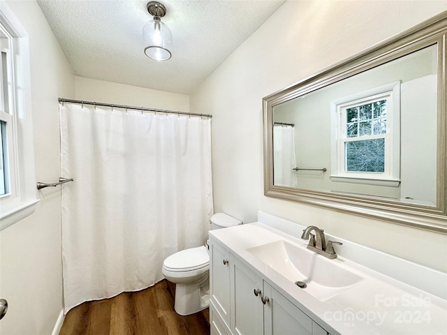 bathroom with toilet, vanity, a textured ceiling, and hardwood / wood-style flooring